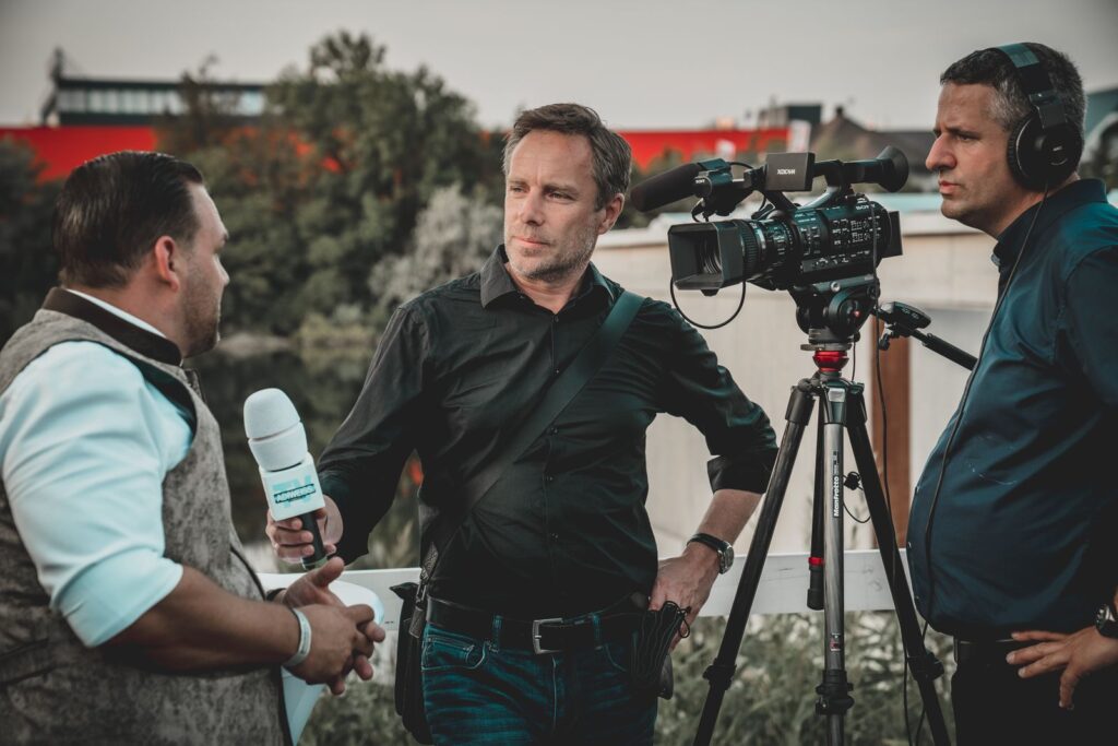 Un equipo de televisión entrevista a un portavoz en la calle