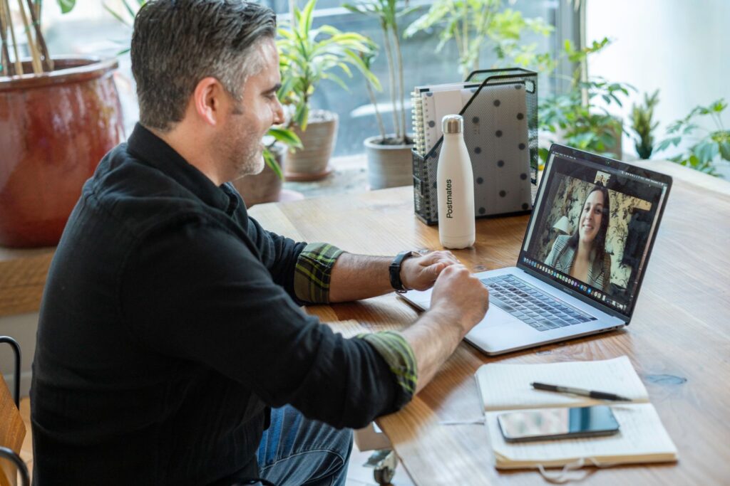 Un profesional participa en una reunión virtual desde su escritorio