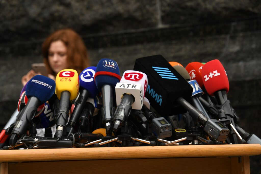Micrófonos de varios medios preparados para una rueda de prensa