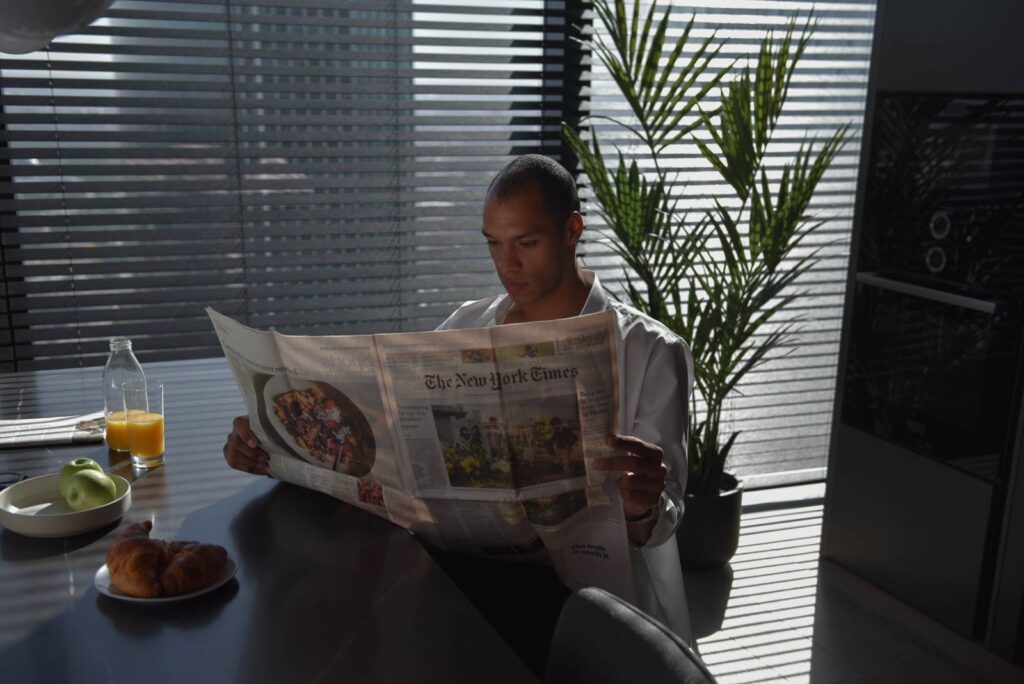 Una persona lee el periódico durante el desayuno