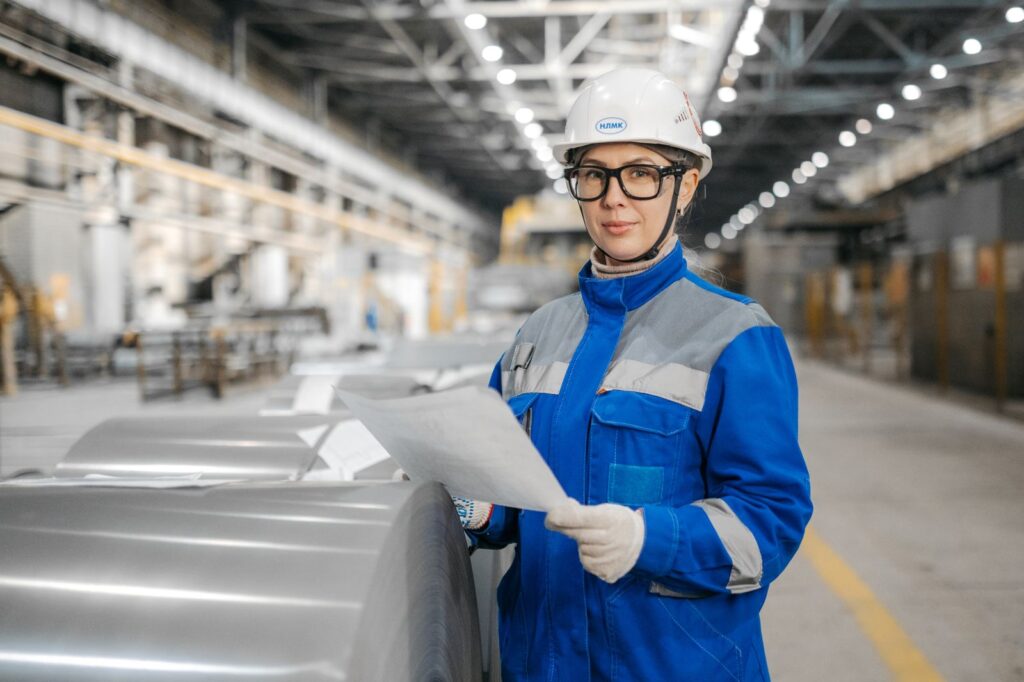Una ingeniera con equipo de seguridad revisa documentación en una fábrica