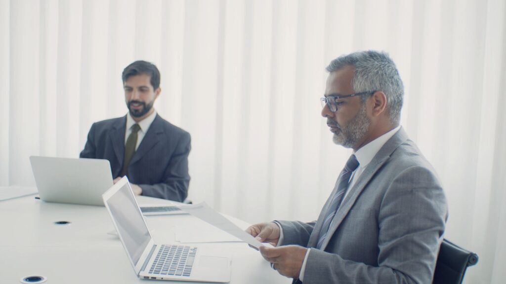 Un profesional joven y un directivo veterano trabajan juntos en la oficina